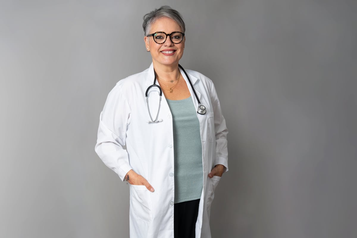 Smiling mature female doctor in white coat